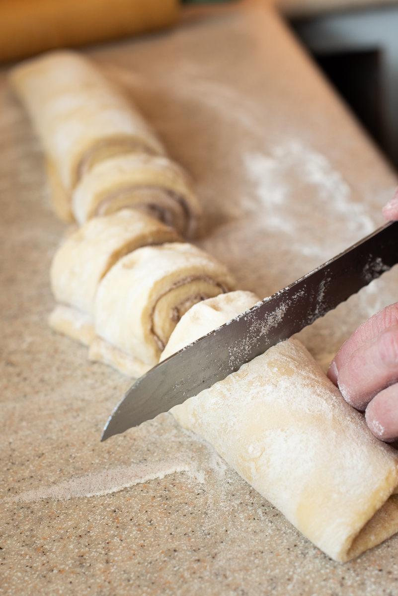 slicing cinnamon rolls