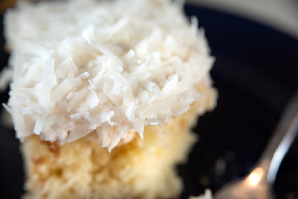 Super Simple Coconut Cake is a  take on a traditional coconut cake. This moist, white cake is infused with sweet condensed milk and topped with a fluffy cream cheese frosting, then coated with sweet coconut.